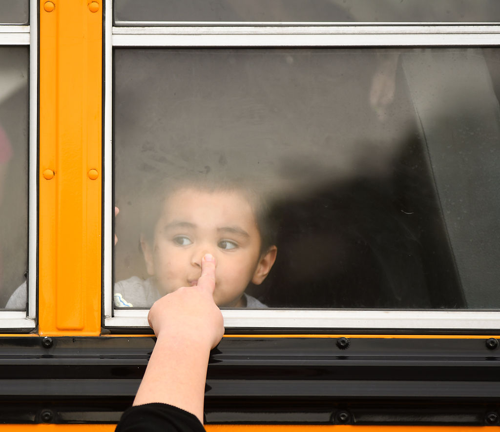 Noah Rodriguez, 2, leans on the window of a school bus for the sensory-friendly Touch-a-Truck event